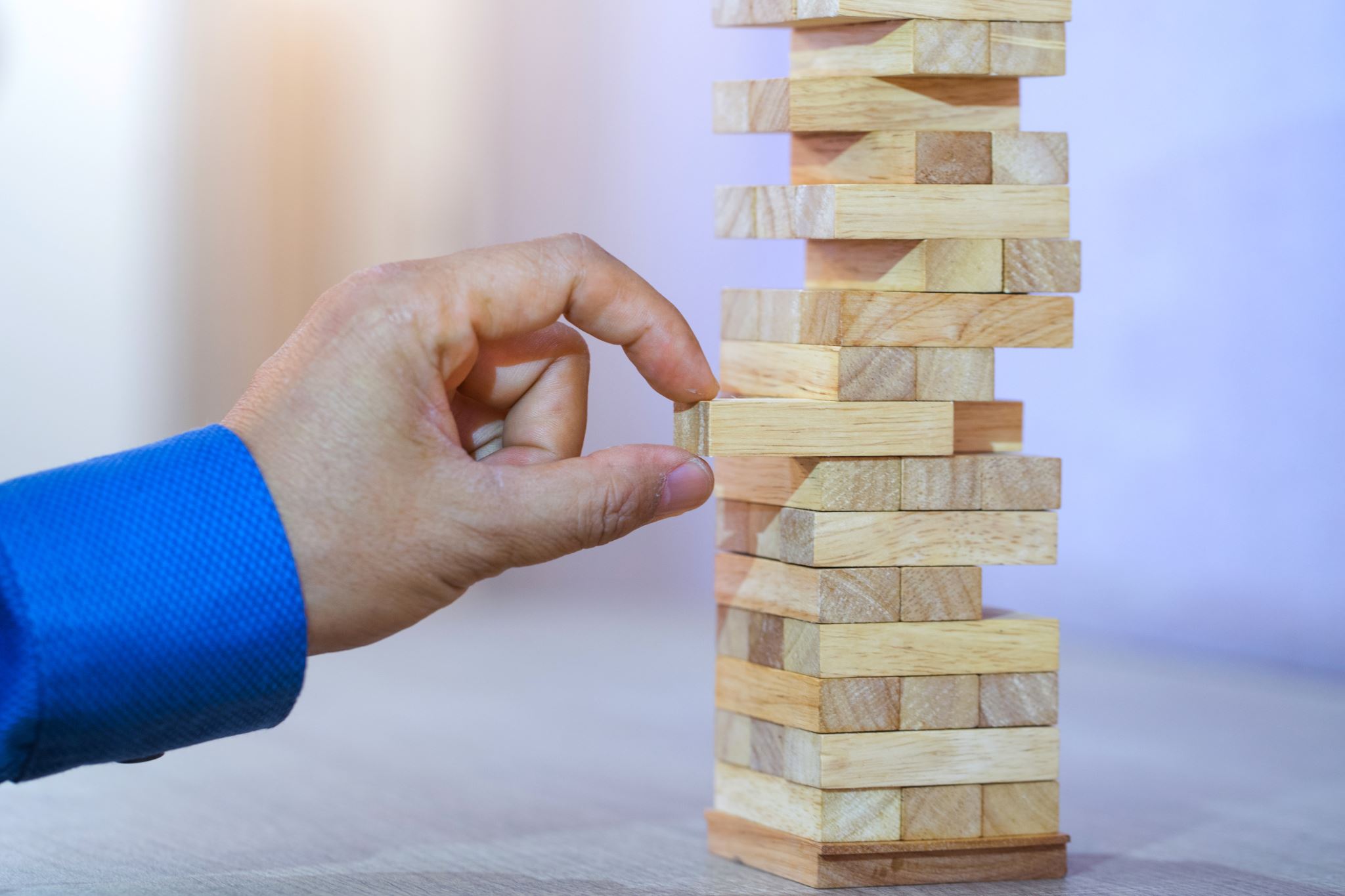 Hand balancing wooden blocks representing risk management